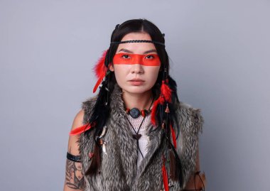 Yüzü açık gri arka planda olan şaman kadın.