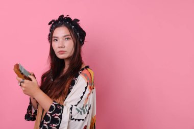 Pembe arka planda kalimba olan tüylü başlıklı şaman kadın, mesaj için yer.