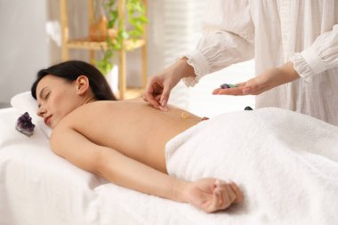 Aurasını içeride iyileştirmek ya da iyileştirmek için kristal terapi gören bir kadın.