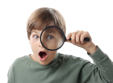 Beyaz arka planda büyüteç olan küçük çocuk şaşırdı.