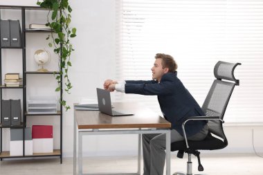 Genç işadamı ofiste kollarını açıyor.