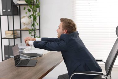 Genç işadamı ofiste kollarını açıyor.