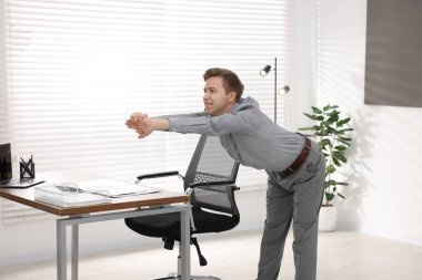 Genç İşadamı Ofiste Esneme Egzersizi Yapıyor