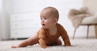 Evde yerde yatan şirin bir bebeğin portresi.