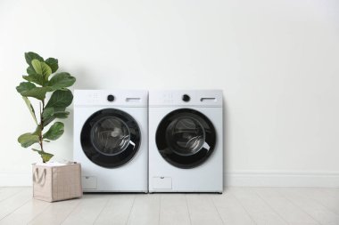 Geniş çamaşır odasında çamaşır ve çamaşır kurutma makinesi.