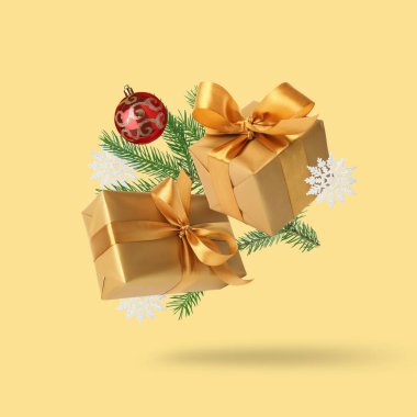 Noel ya da yeni yıl kutlaması. Hediye kutuları ve sarı arka planda havadaki şenlikli dekorasyon.