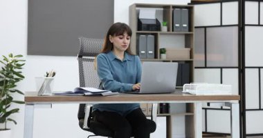 Ofiste kollarını açan genç iş kadını.