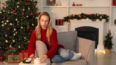 Evdeki koltukta sıcak kakao içen güzel bir kadın. Noel sezonu