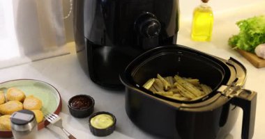 Pişmemiş patates kızartması, tavuk nugget, soslar ve baharatlar beyaz mermer tezgahta, yakın plan. Kamera içeri giriyor.