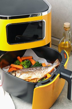 Izgara balık ve sebzeler gri masada, yakın plan.