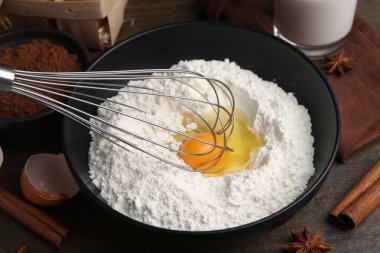 Hamur ve çırpma malzemeleri ahşap masada, yakın plan.