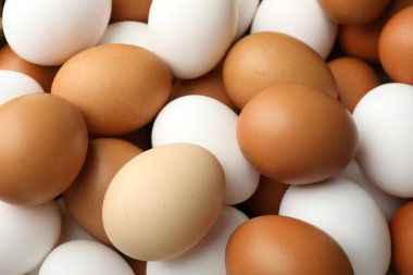 Arka plan olarak birçok çiğ tavuk yumurtası, yakın plan.