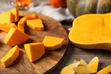 Balkabağını ve kabuklarını tahta masada kes, yakın plan.