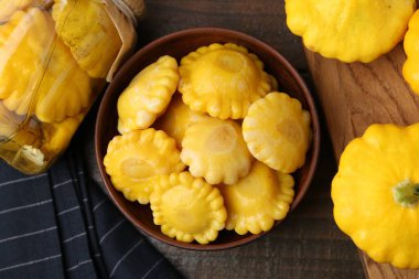 Kabın içinde turşu kabağı turşusu, kavanoz ve ahşap masanın üstünde taze kabak.