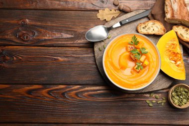 Tahta masada servis edilen maydanozlu lezzetli balkabağı kremalı çorba. Metin için boşluk
