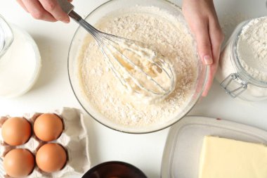 Beyaz masada hamuru yapan kadın (sıvı hamur), üst görünüm