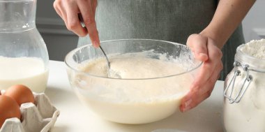 Beyaz masada hamuru hazırlayan kadın, yakın plan.