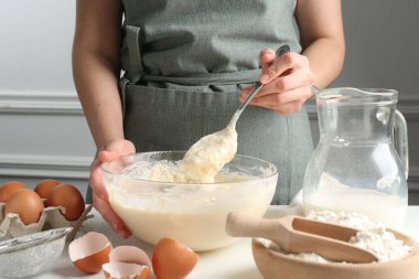 Beyaz masada hamuru hazırlayan kadın, yakın plan.