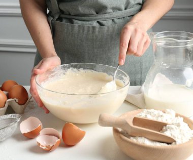 Beyaz masada hamuru hazırlayan kadın, yakın plan.