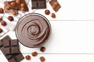 Erimiş çikolata ve fındıklı beyaz ahşap masa, düz. Metin için boşluk