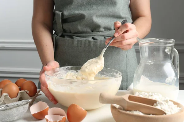 Beyaz masada hamuru hazırlayan kadın, yakın plan.