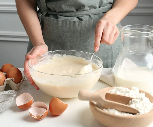 Beyaz masada hamuru hazırlayan kadın, yakın plan.