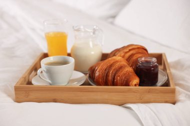 Otel odasındaki yatakta nefis bir kahvaltı tepsisi, yakın plan.