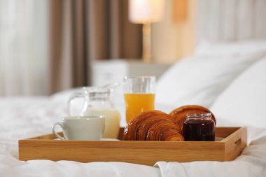 Otel odasındaki yatakta nefis bir kahvaltı tepsisi, yakın plan. Metin için boşluk