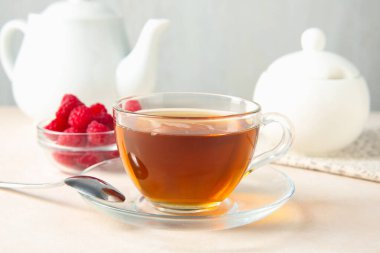 Lezzetli çay ve ahududular beyaz masada, yakın plan.