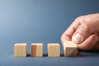 Gri arka planda tahta küpleri olan adam, yakın plan. Metin için boşluk