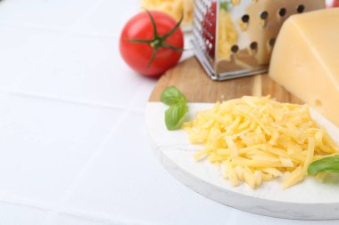 Öğütücü, domates, fesleğen, rendelenmiş peynir ve beyaz masa, yakın plan. Metin için boşluk