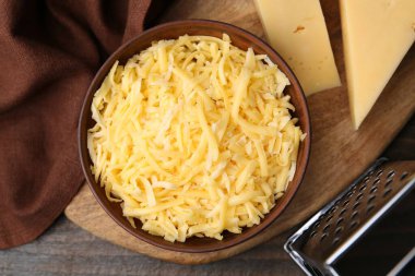 Öğütücü, rendelenmiş ve peynir parçaları ahşap masada, düz yatıyordu.