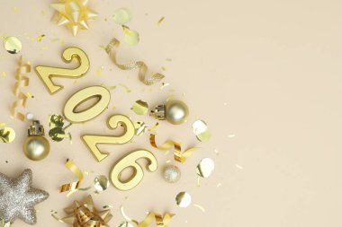 Yeni yıl 2026. Altın sayılar, parlak mücevherler ve bej arka planda konfeti. Metin için boşluk