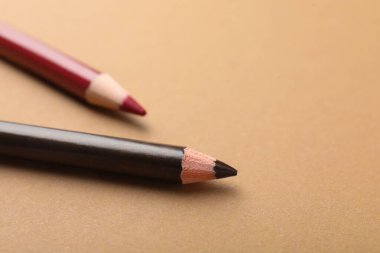 Kahverengi arka planda göz kalemleri, yakın plan. Metin için boşluk