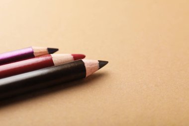 Kahverengi arka planda göz kalemleri, yakın plan. Metin için boşluk