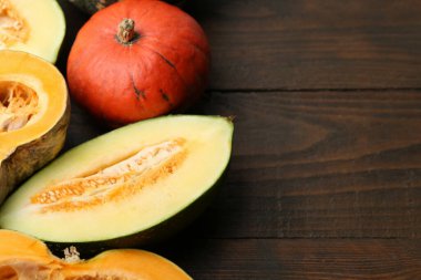 Tahta masada bir sürü taze balkabağı ve kavun, yazı için yeri olan yakın plan. Su kabağı ailesi