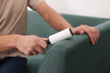 Evdeki pamuklu bezle kanepeyi temizleyen adam, yakın çekim.