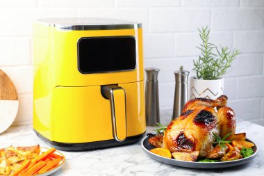 Lezzetli ızgara tavuk biberiyeli, sebzeli ve beyaz mermer masada kızartma makinesi.