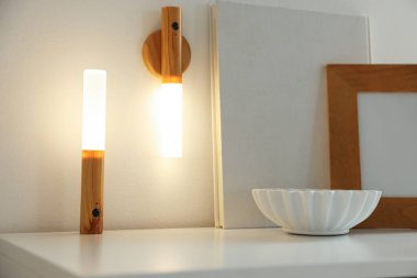 Evdeki beyaz masada taşınabilir LED lambalar ve dekor, yakın plan.