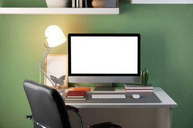 Ofisinde bilgisayar ve gri paspas olan şık bir iş yeri.