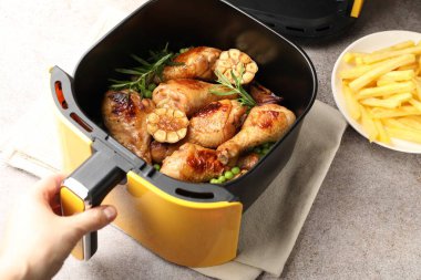 Gri masada tavuklu tavuk budu pişiren bir kadın.