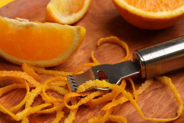 Turuncu tat, taze meyve ve zester aleti ahşap tabakta, yakın plan.