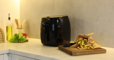 Kızartma makinesi, patates kızartması, soslar ve sebzeler beyaz mermer tezgahta, kamera içeri giriyor.