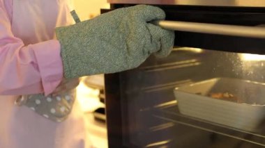 Fırından fırın kabağı ile fırın kabağı alan kadın, yakın plan. Kamera içeri giriyor.