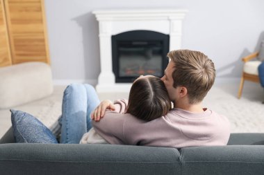 Kanepede şömineli sevimli bir çift