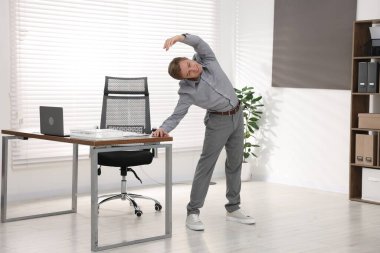 Genç İşadamı Ofiste Esneme Egzersizi Yapıyor