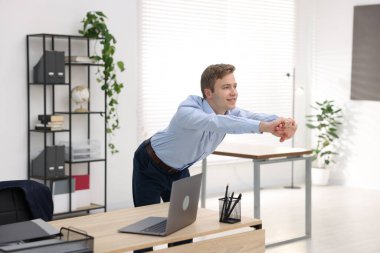 Genç İşadamı Ofiste Esneme Egzersizi Yapıyor