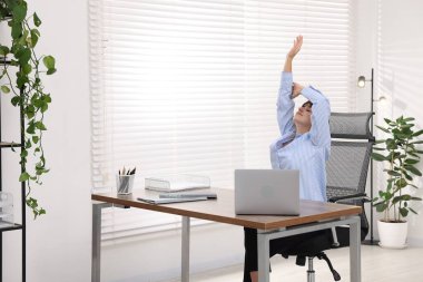 Genç iş kadını ofiste kolunu uzatıyor.