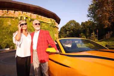 Modern Cabriolet yakınlarında güneş gözlüklü şık bir çift.