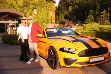 Modern Cabriolet yakınlarında güneş gözlüklü şık bir çift.